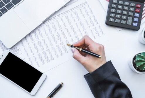 hand-holding-fountain-pen-office-desk_23-2147965627